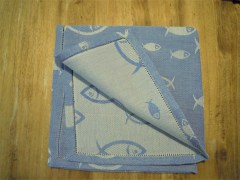 Tovagliolo, tessitura artigianale in misto lino/cotone, disegno con pesci di colore azzurro, finitura a punto giorno, cm 40x40open stitch, grey color available in size cm 40x40.